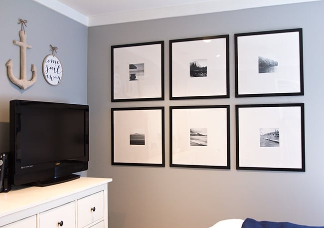 bedroom with gallery wall with black frames and black and white photographs