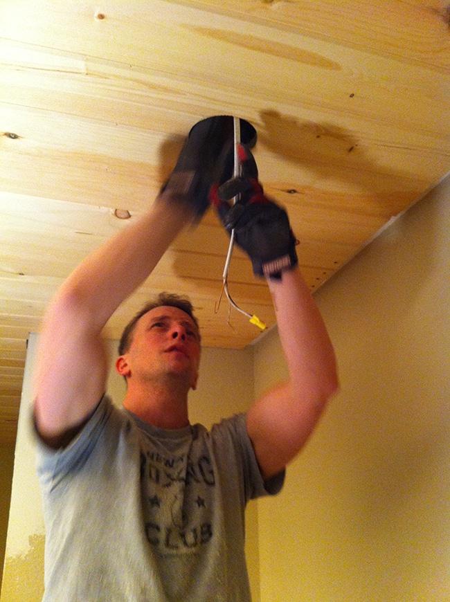 drilling a hole into a wood ceiling for a light
