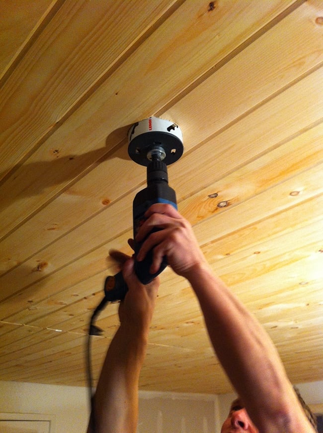 drilling a hole into a wood ceiling for a light