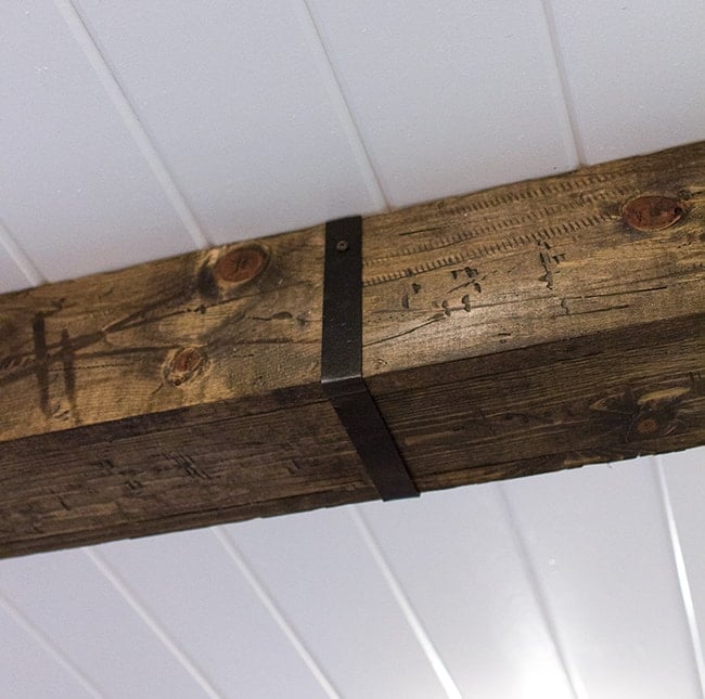 closeup of black metal strap on a wood ceiling beam