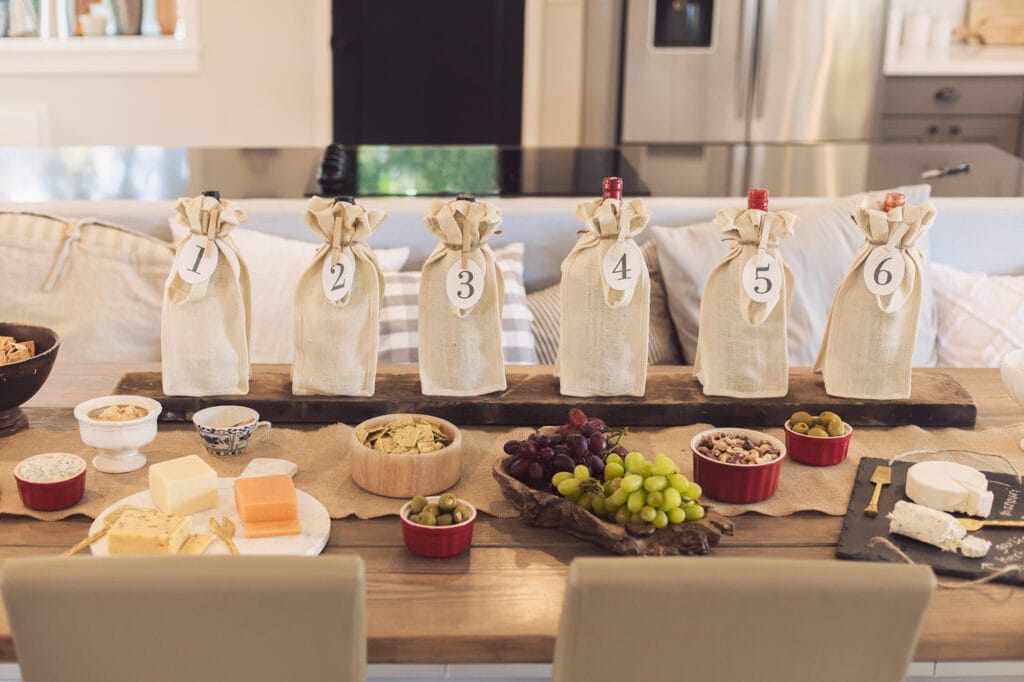 wine tasting party table setup with wine bottles and snacks