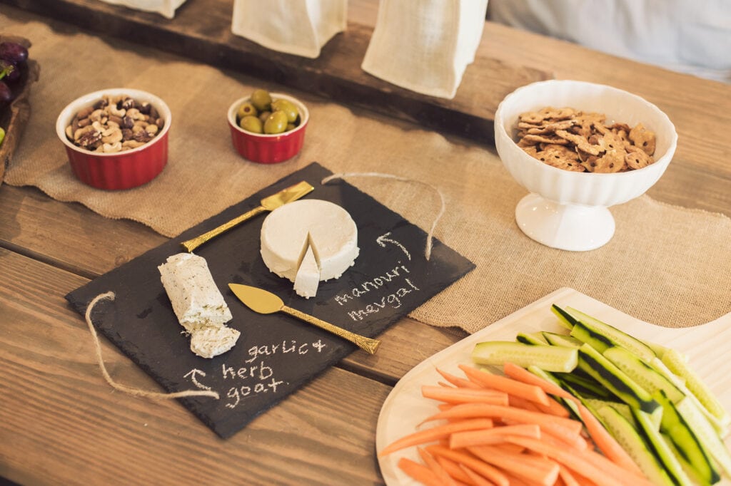 dining table with cheese board, veggies and snacks