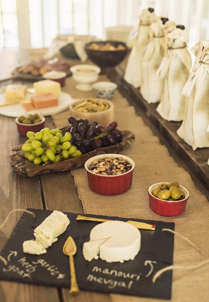 wine tasting party table set with grapes, cheese and snacks