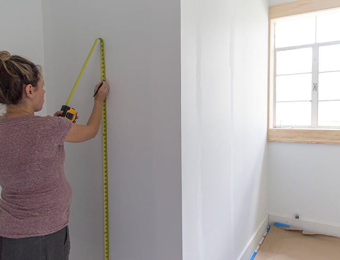 measuring the wall during a board and batten installation