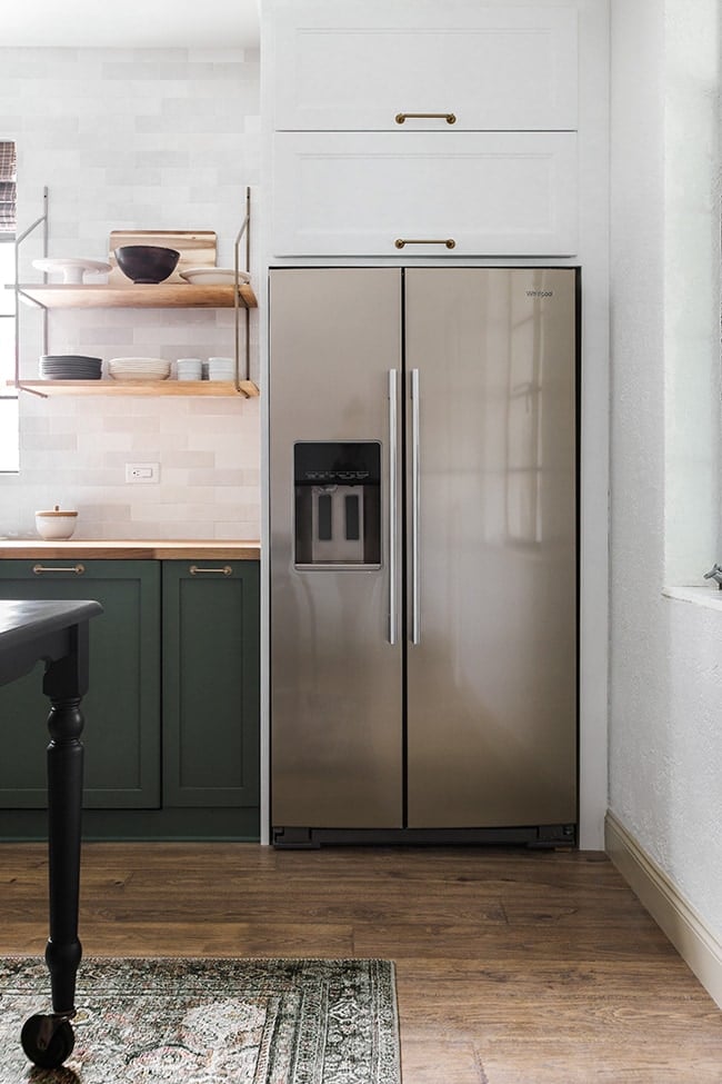 kitchen with green cabinets and a white custom fridge surround