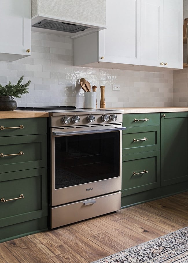 kitchen with green lower cabinets, subway tile and a range