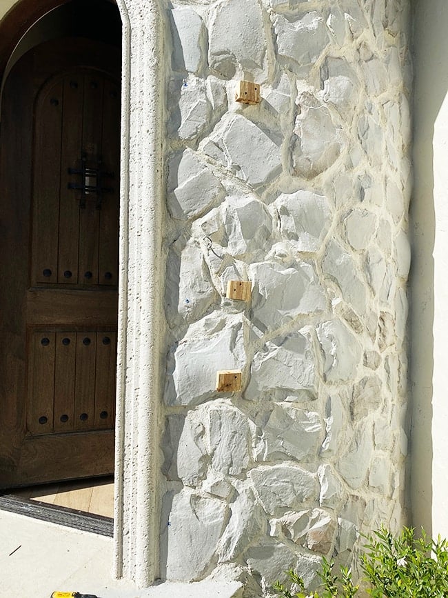 installing shutters on a stone wall