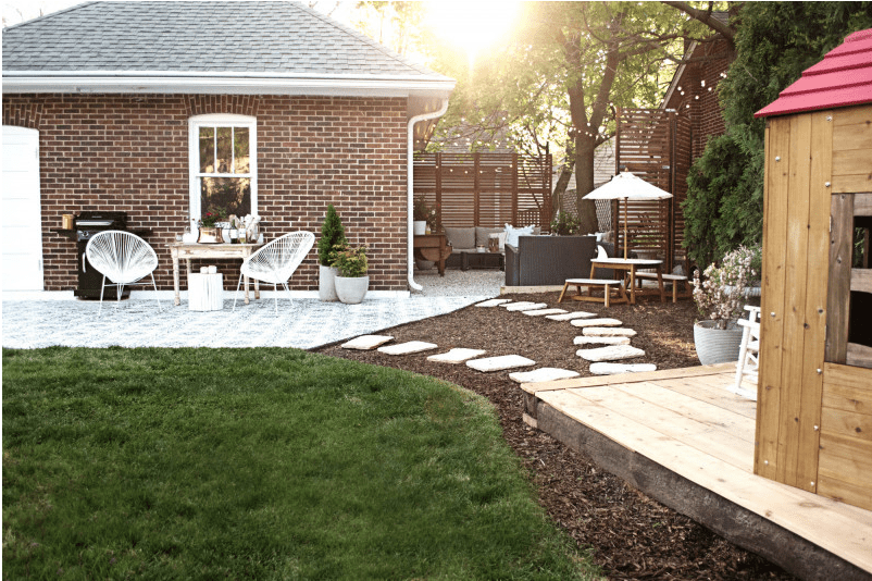 diy backyard with mulch and a brick house