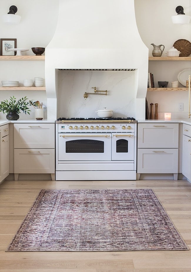 neutral kitchen with open shelving and antique rug