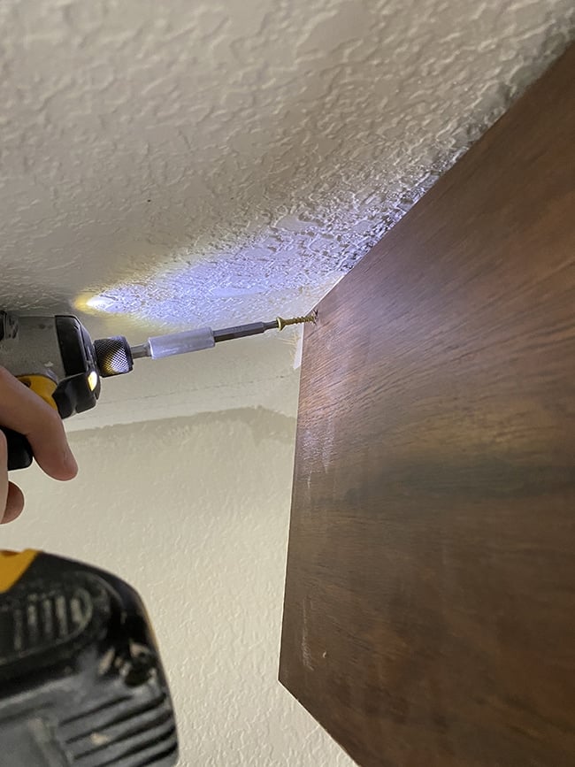 screwing a beam into a vaulted ceiling