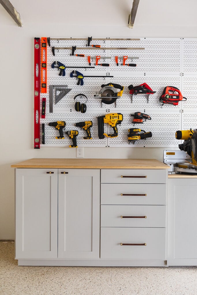 custom garage storage cabinets and white pegboard wall