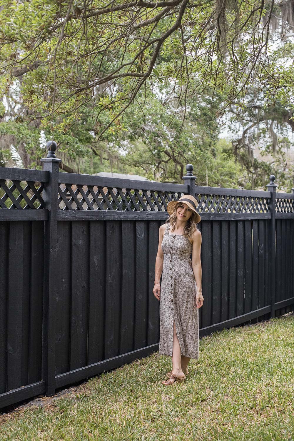 standing next to black wood fence