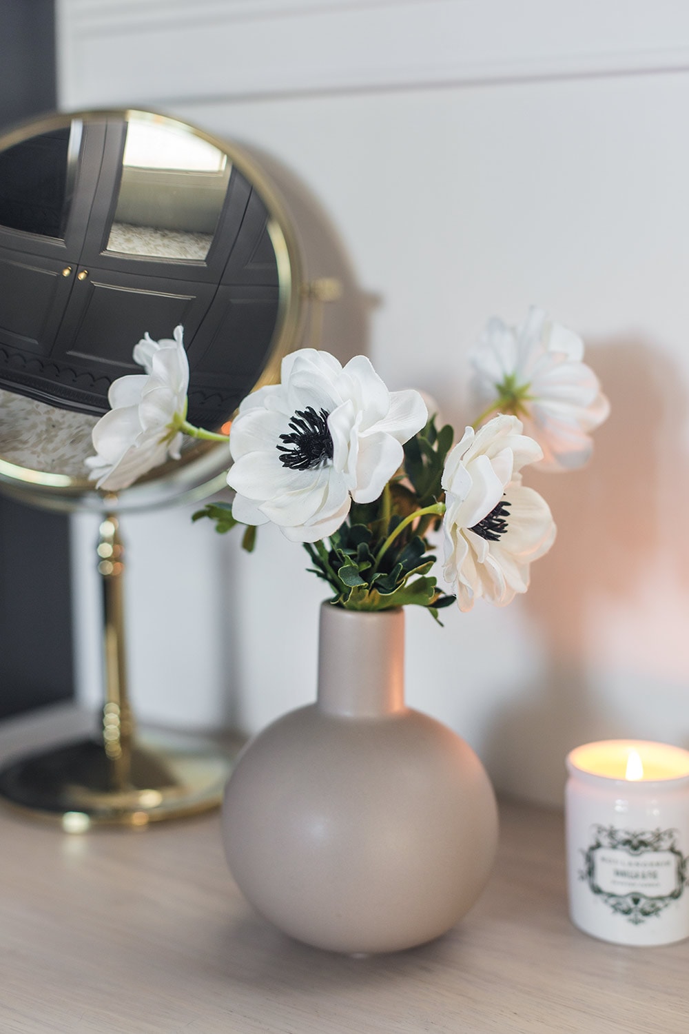 closeup of faux white anemone flowers in bud vase
