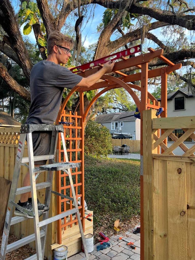 installing a wood arbor to a fence