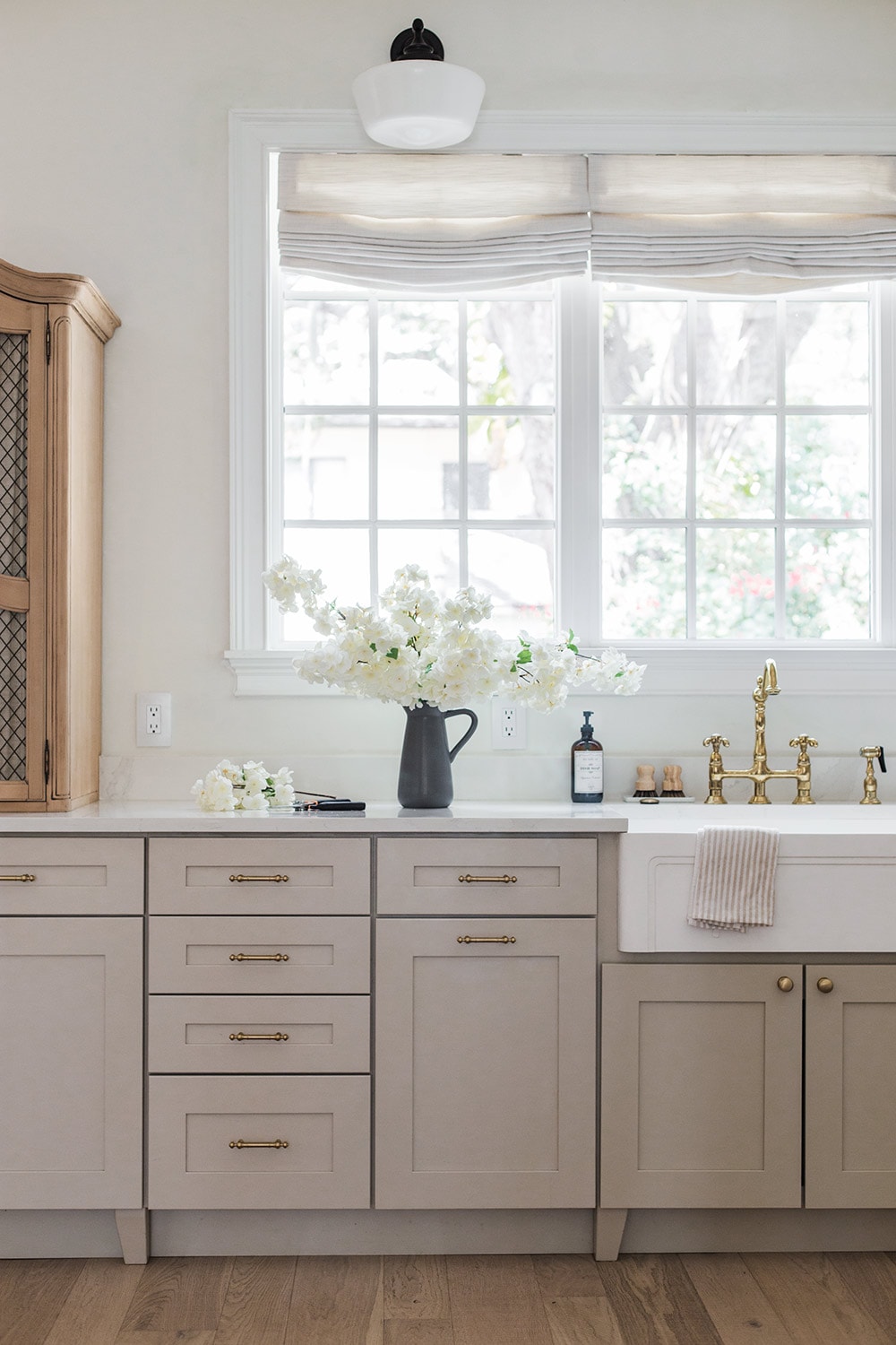 faux white cherry blossoms in vase on kitchen counter