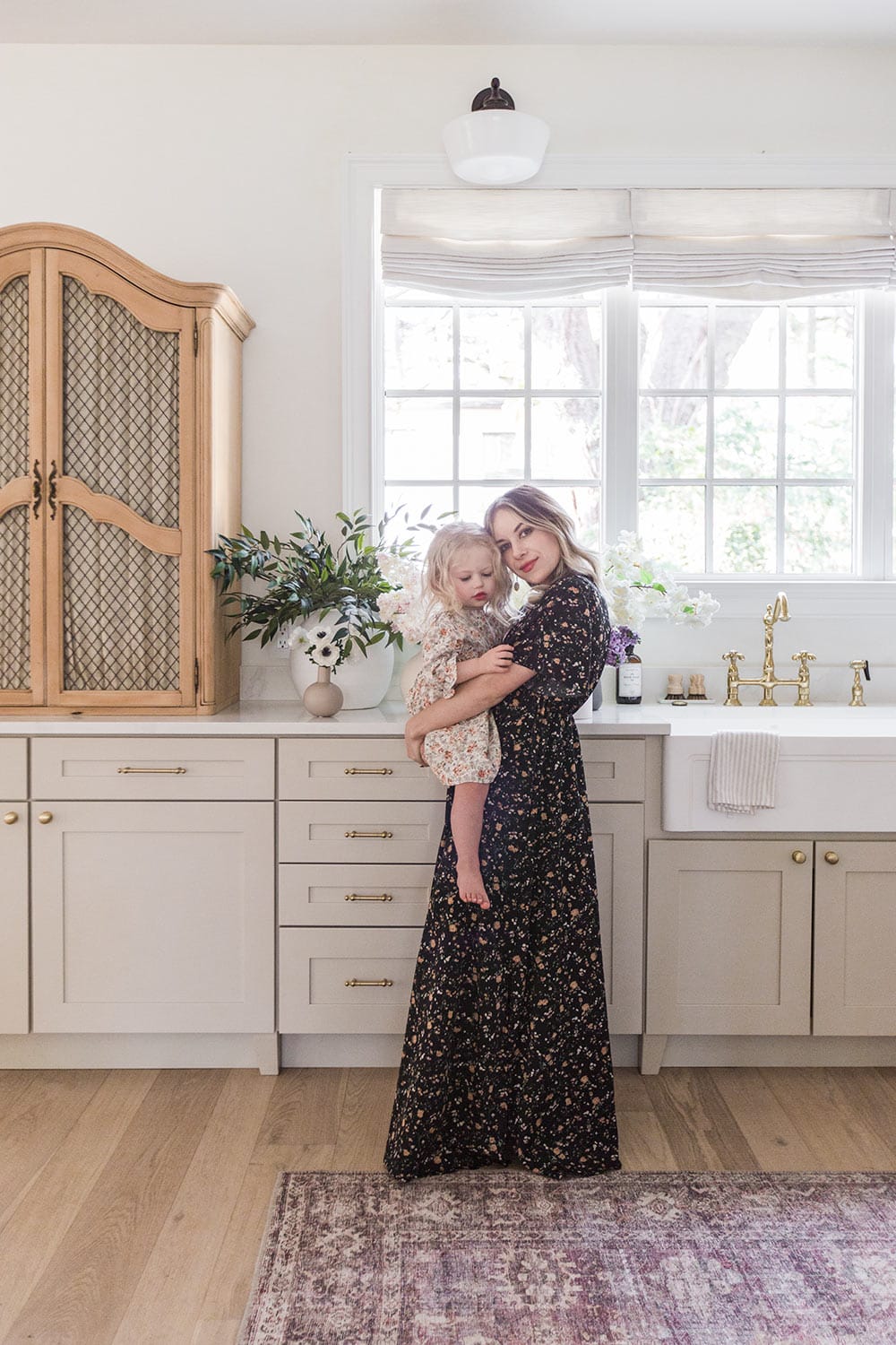 mother and daughter in kitchen in floral dresses