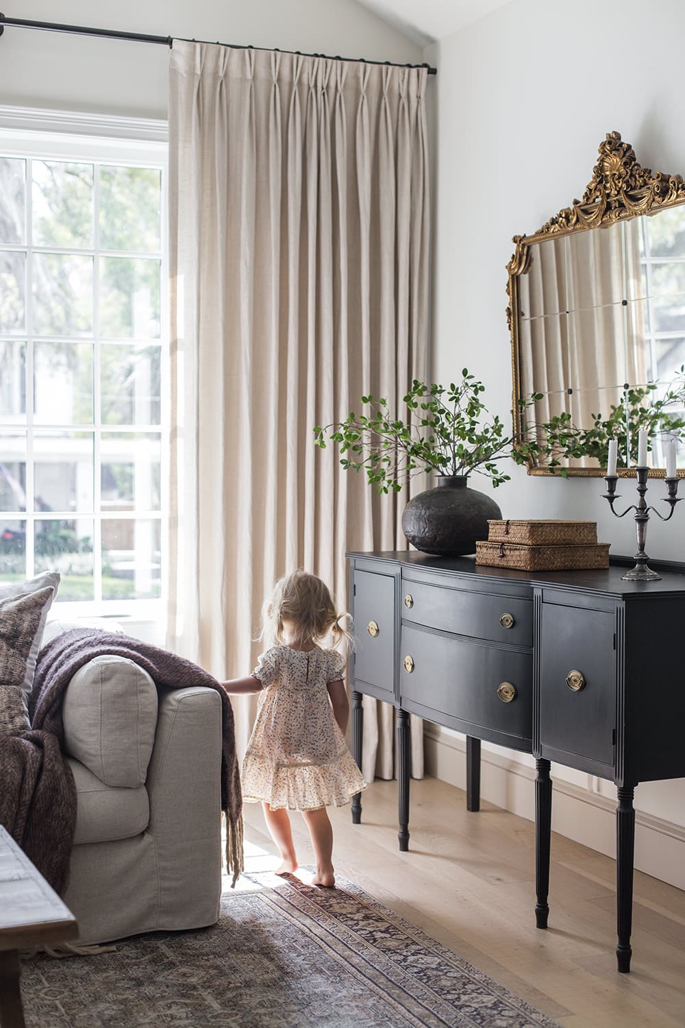 girl walking in front of window in living room