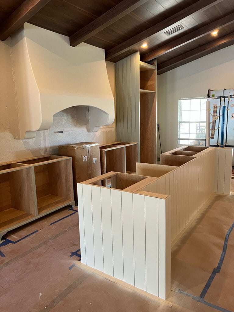 kitchen in progress with ivory island clad in shiplap