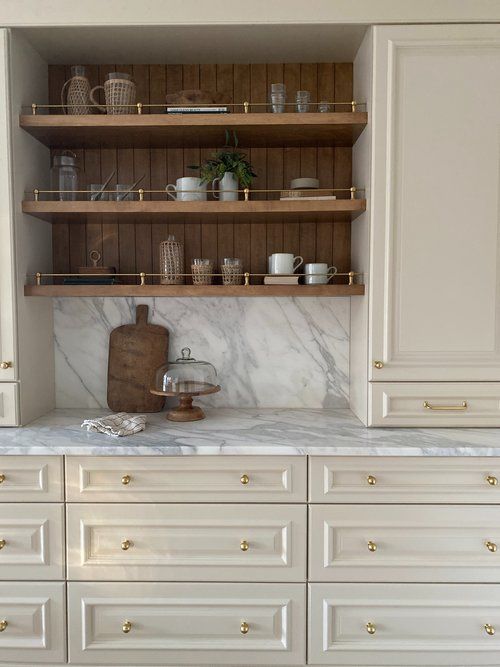 ivory kitchen cabinets with marble counters and open wood shelving