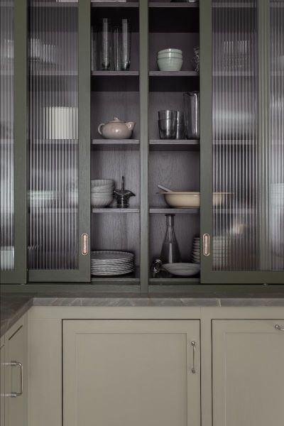 green and beige kitchen with fluted glass cabinet doors