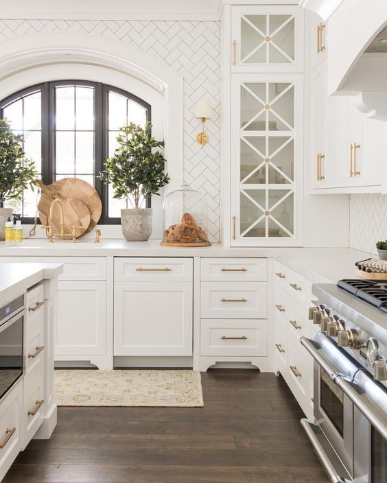 white kitchen with arched window and gold accents