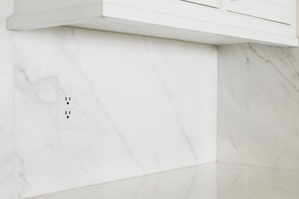 trufig flush mount outlet in a marble backsplash