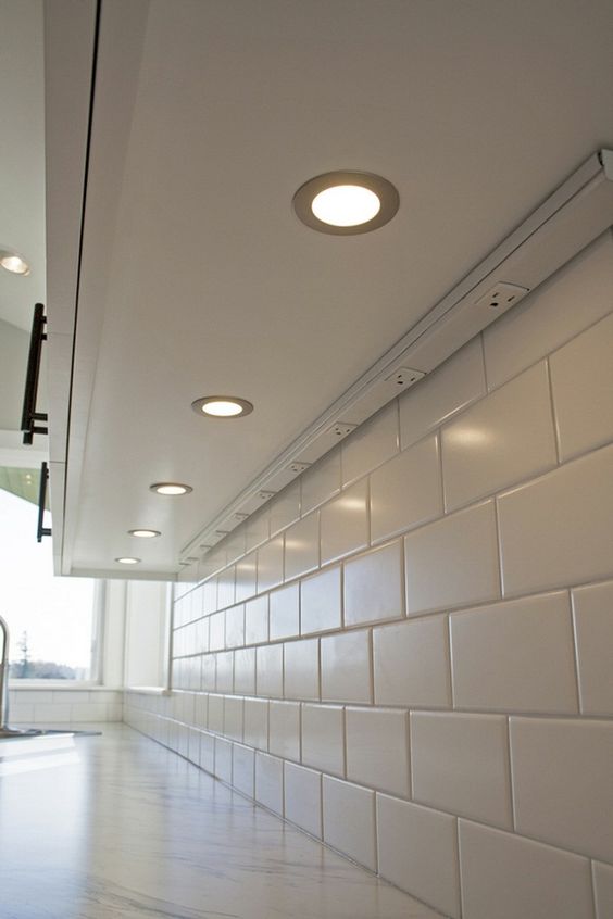 under cabinet power strip with a white subway tile backsplash