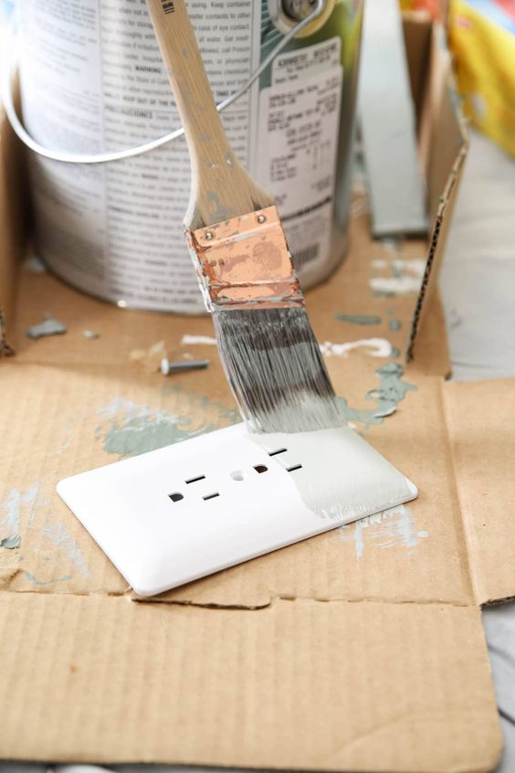 painting a paintable outlet cover plate with a paint brush