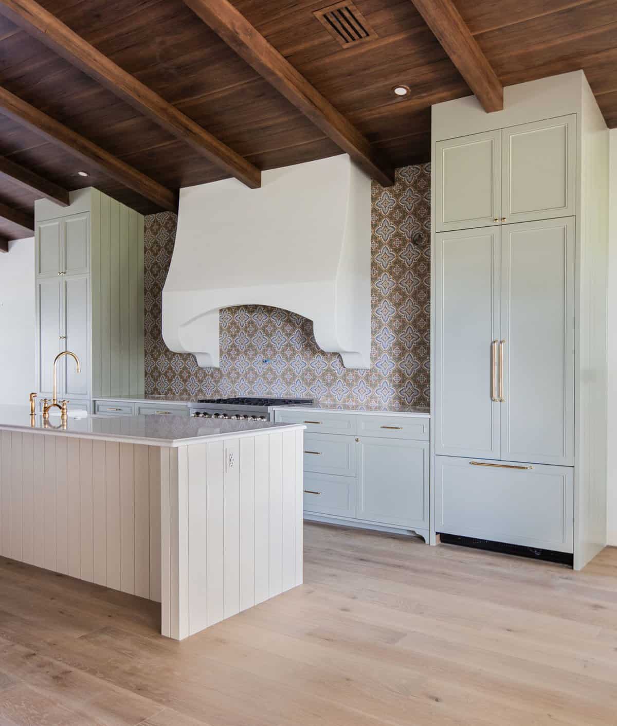 spanish style kitchen with sage green cabinets and patterned tile