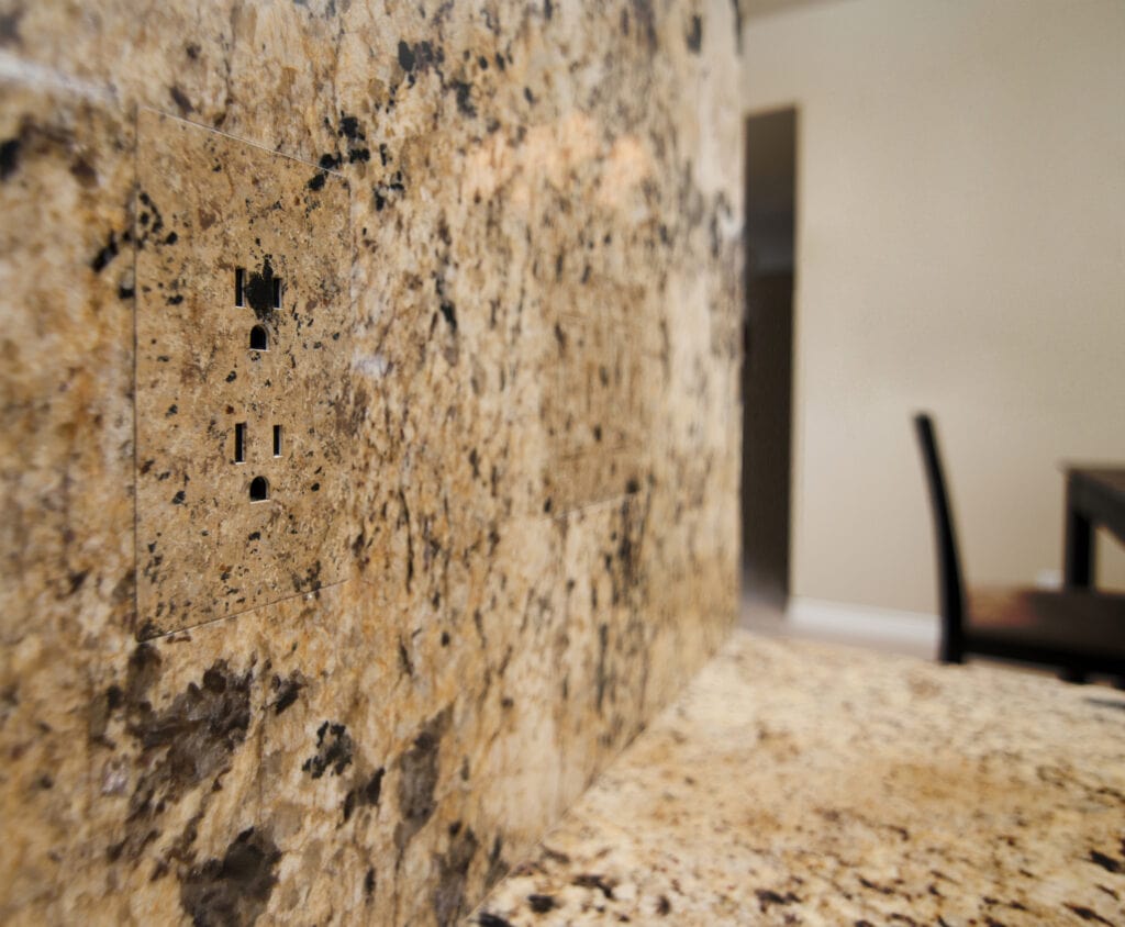 trufig flush mount outlet in a granite  backsplash wall