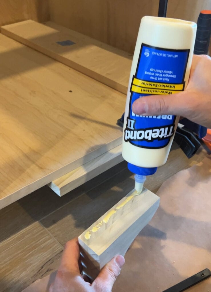 applying wood glue to furniture feet during install