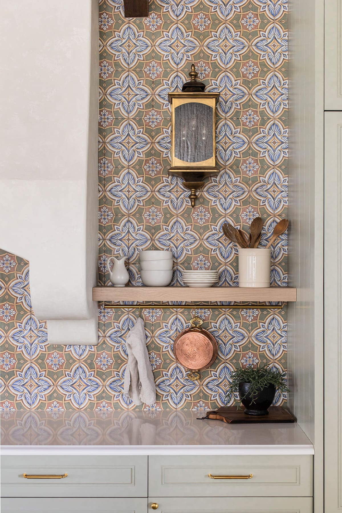 painted tile backsplash with sage green cabinets and shelf