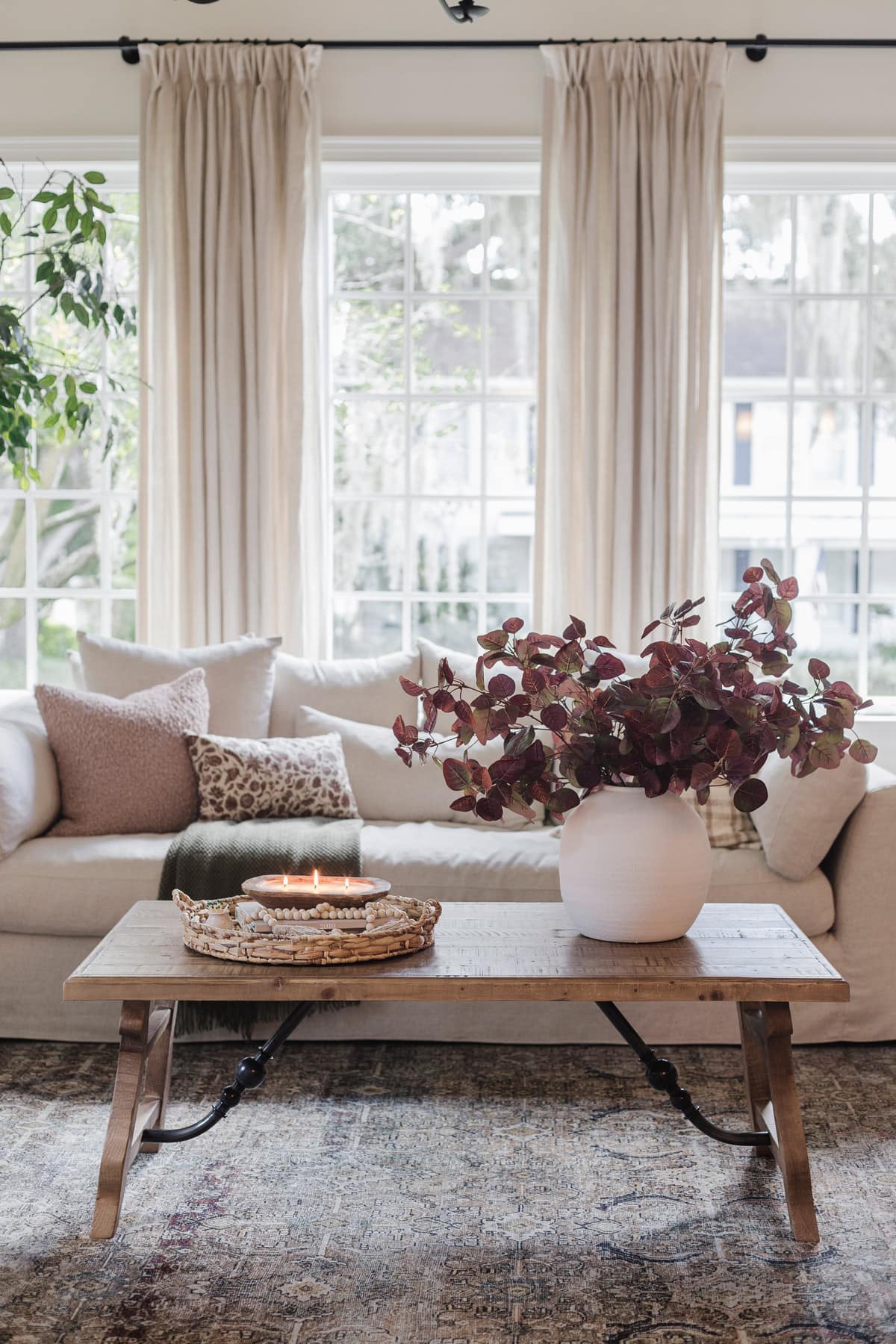 neutral living room with burgundy fall leaves in a large vase