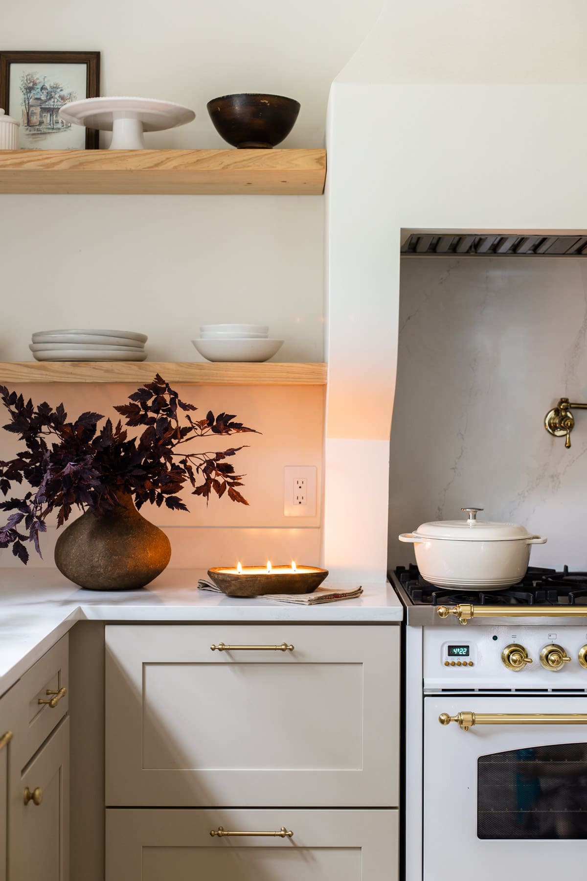 neutral fall kitchen with candle and burgundy stems