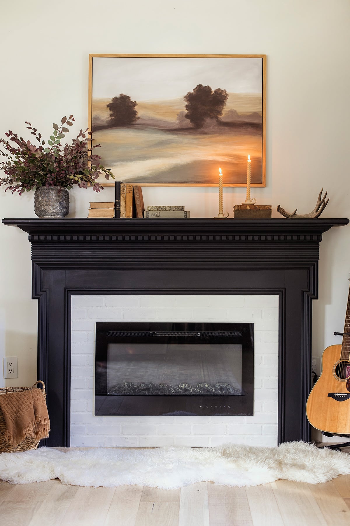 fall fireplace with candles, art and books