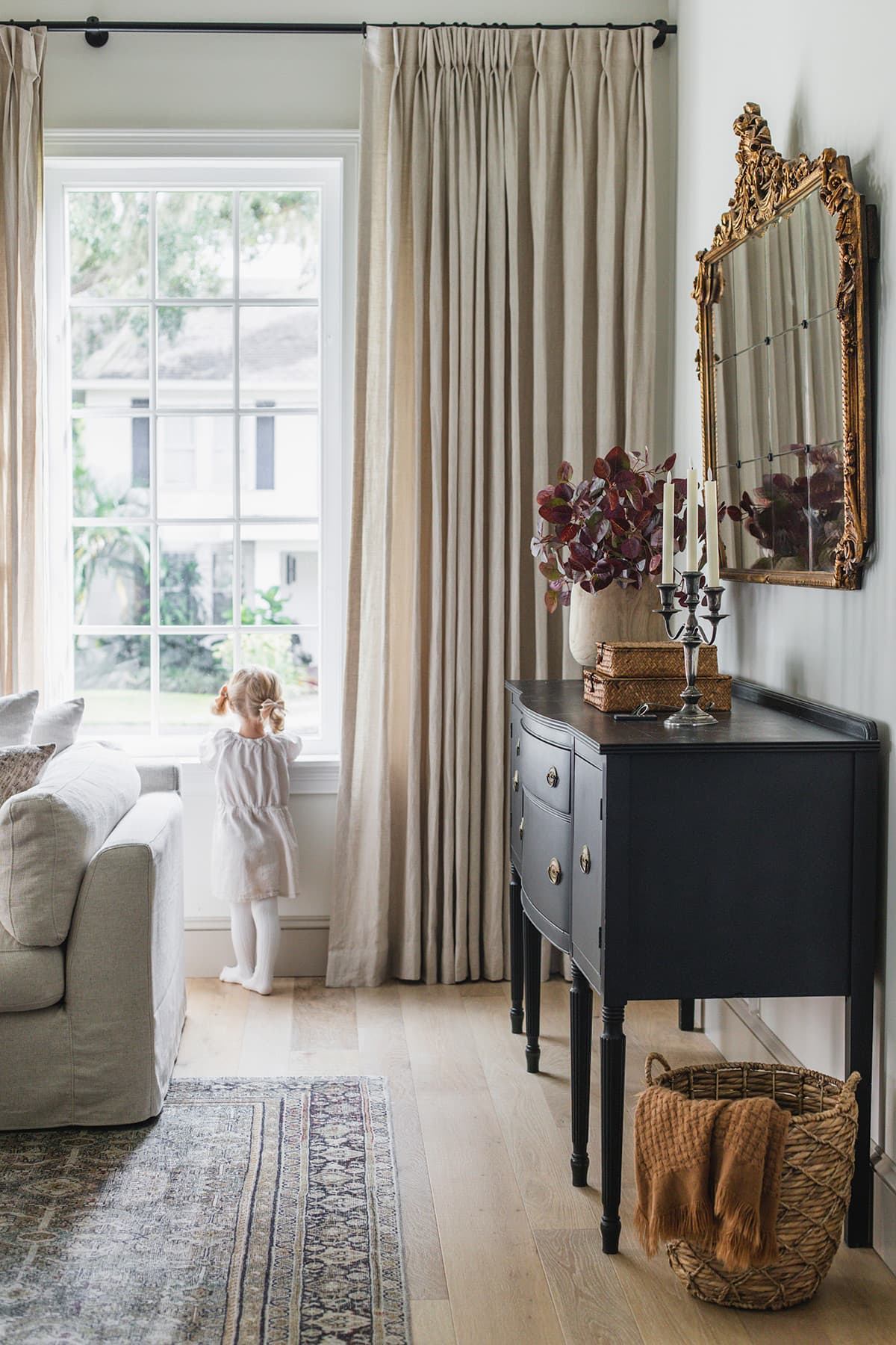 girl looking out window in living room