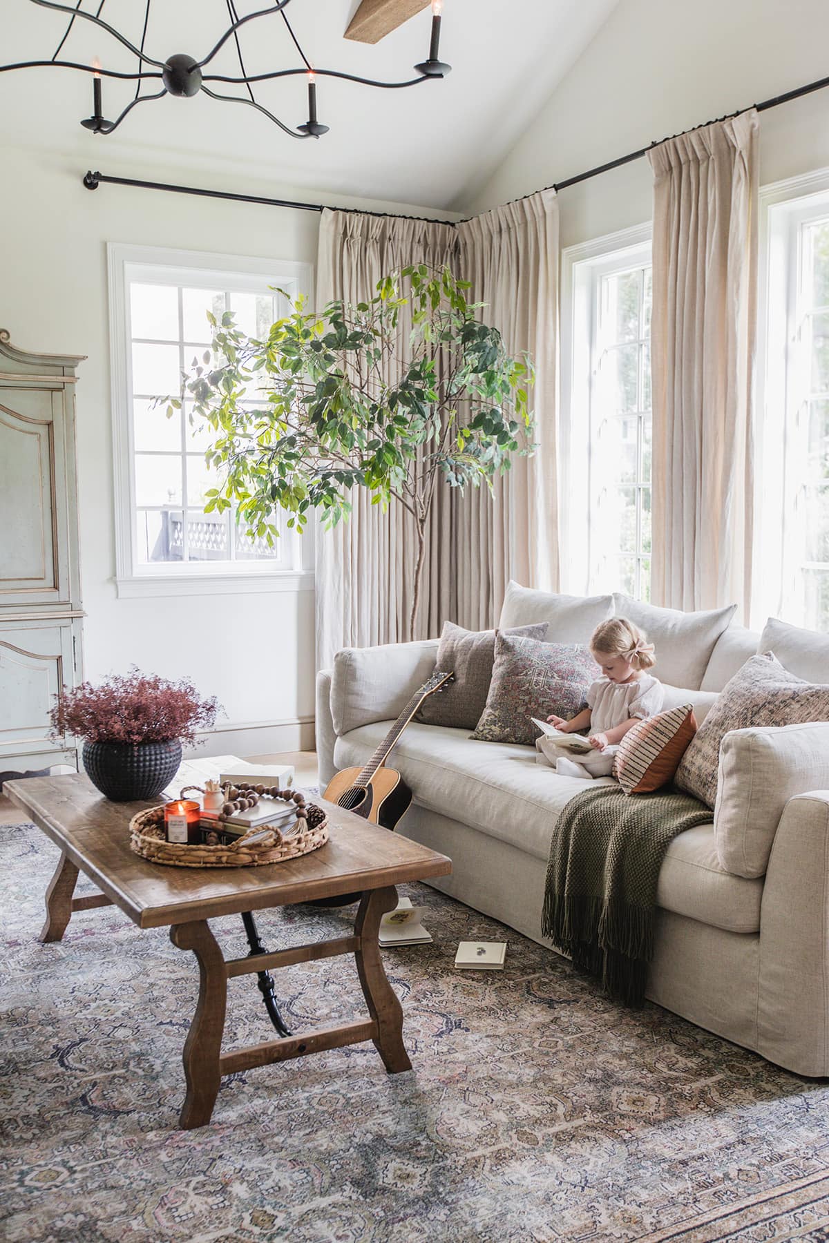 neutral fall living room with girl reading on sofa
