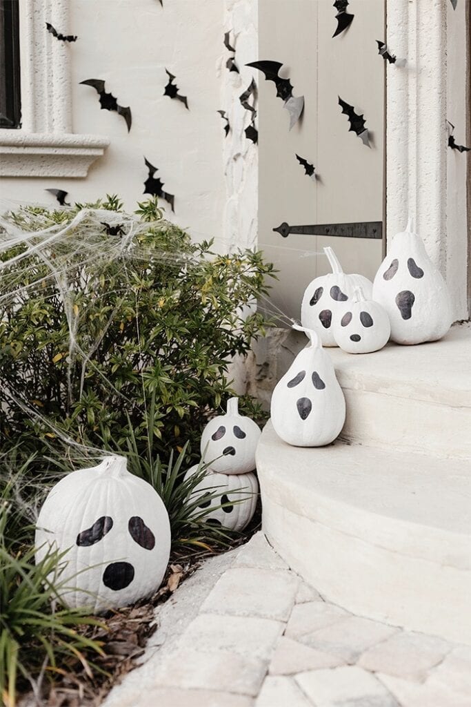 spooky painted ghost pumpkins on front porch