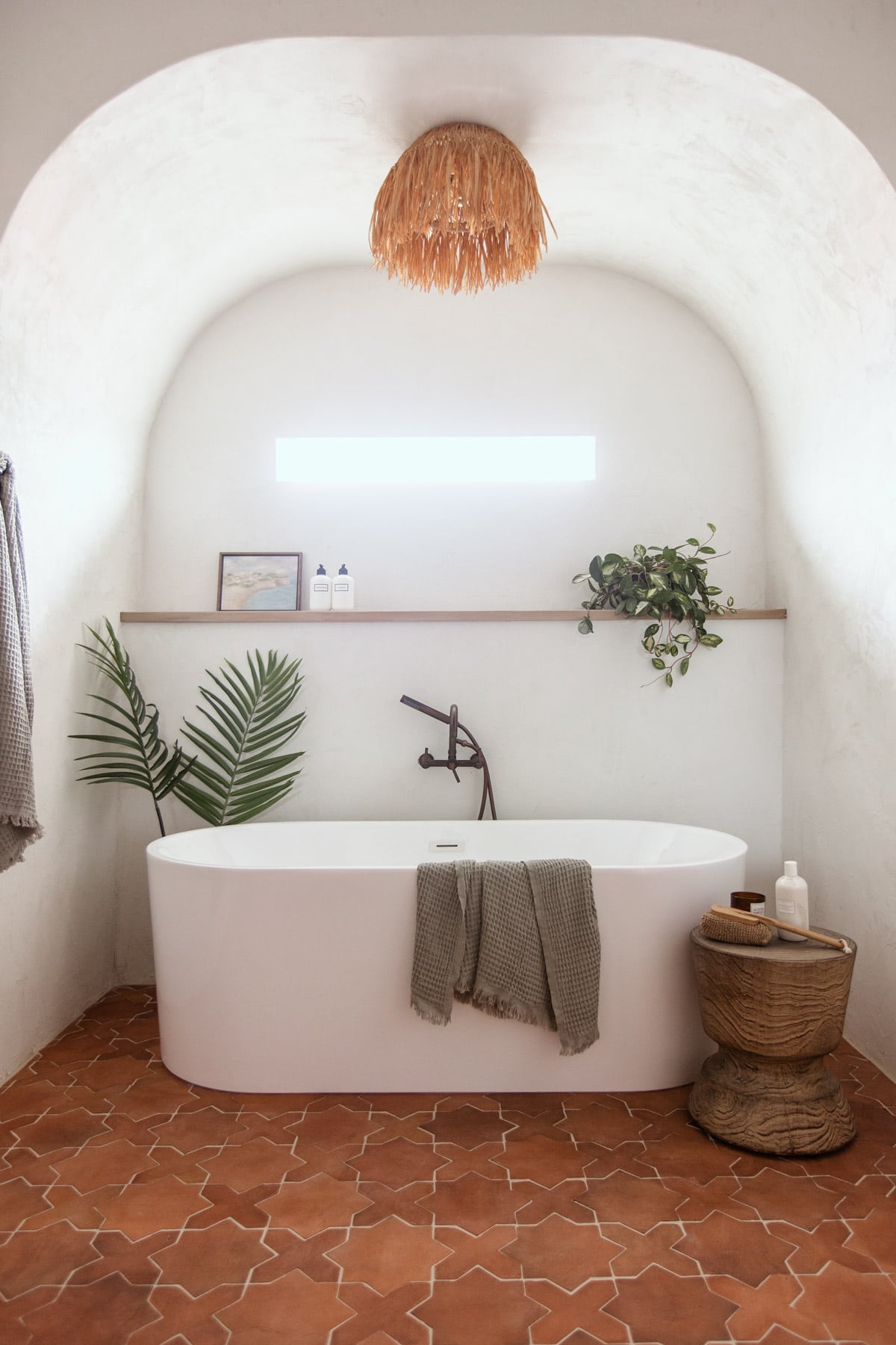 modern mediterranean bathroom with microcement walls and a tub alcove