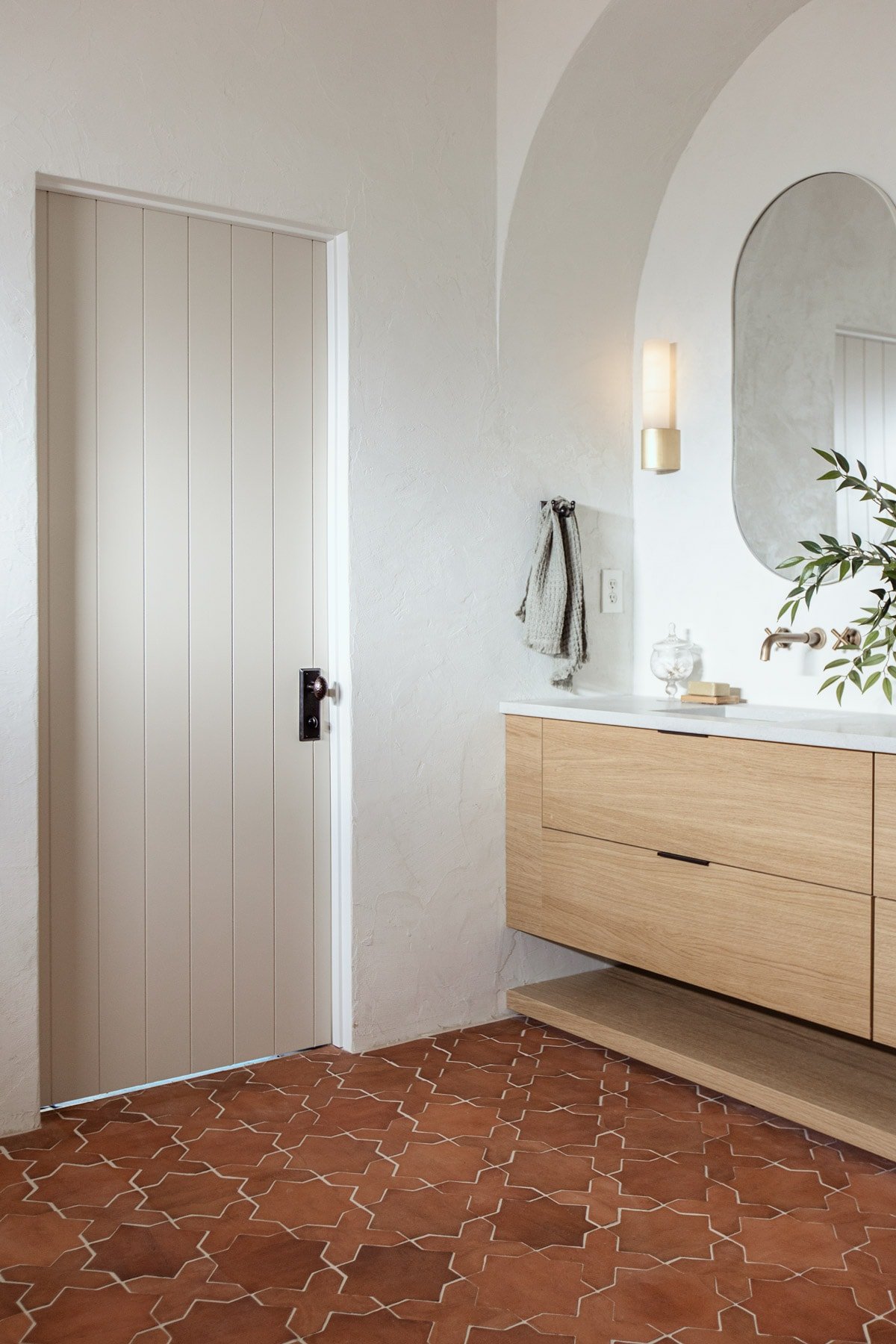 rustic mediterranean bathroom with clay tile and plank door