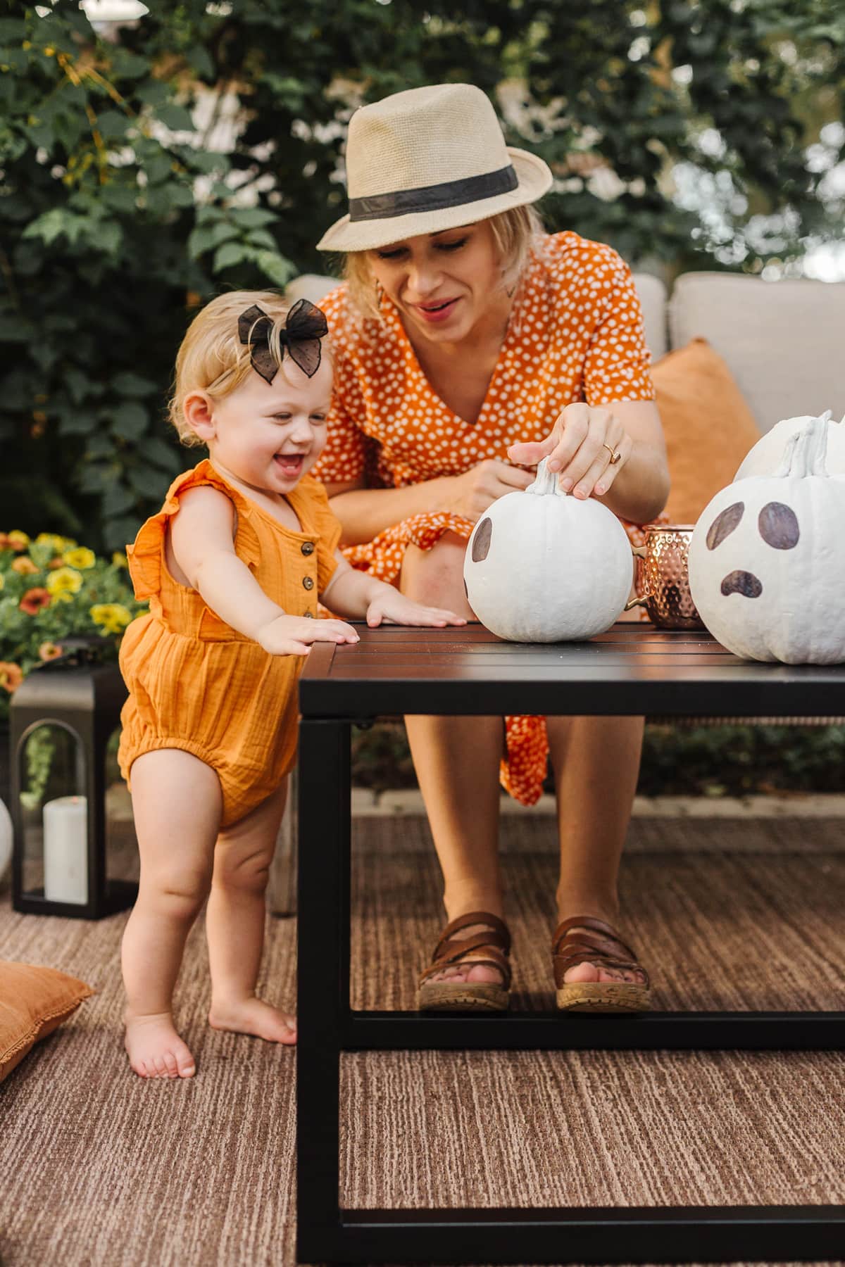 mom and baby painting pumpkins for halloween