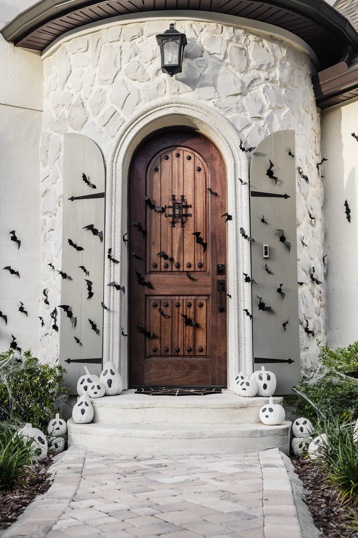 halloween porch with bats and spooky painted ghost pumpkins