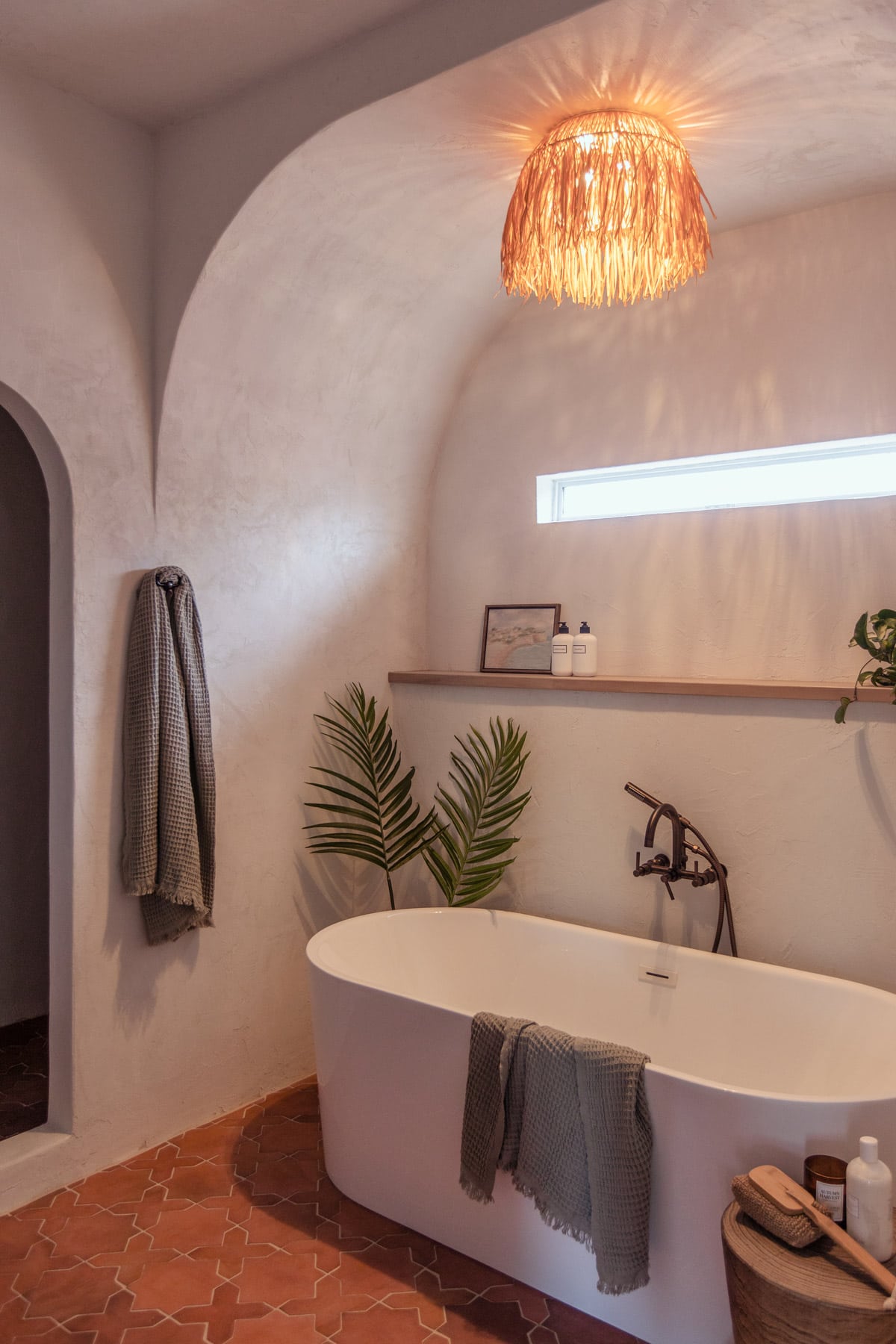 modern mediterranean bathroom with microcement walls and a tub alcove