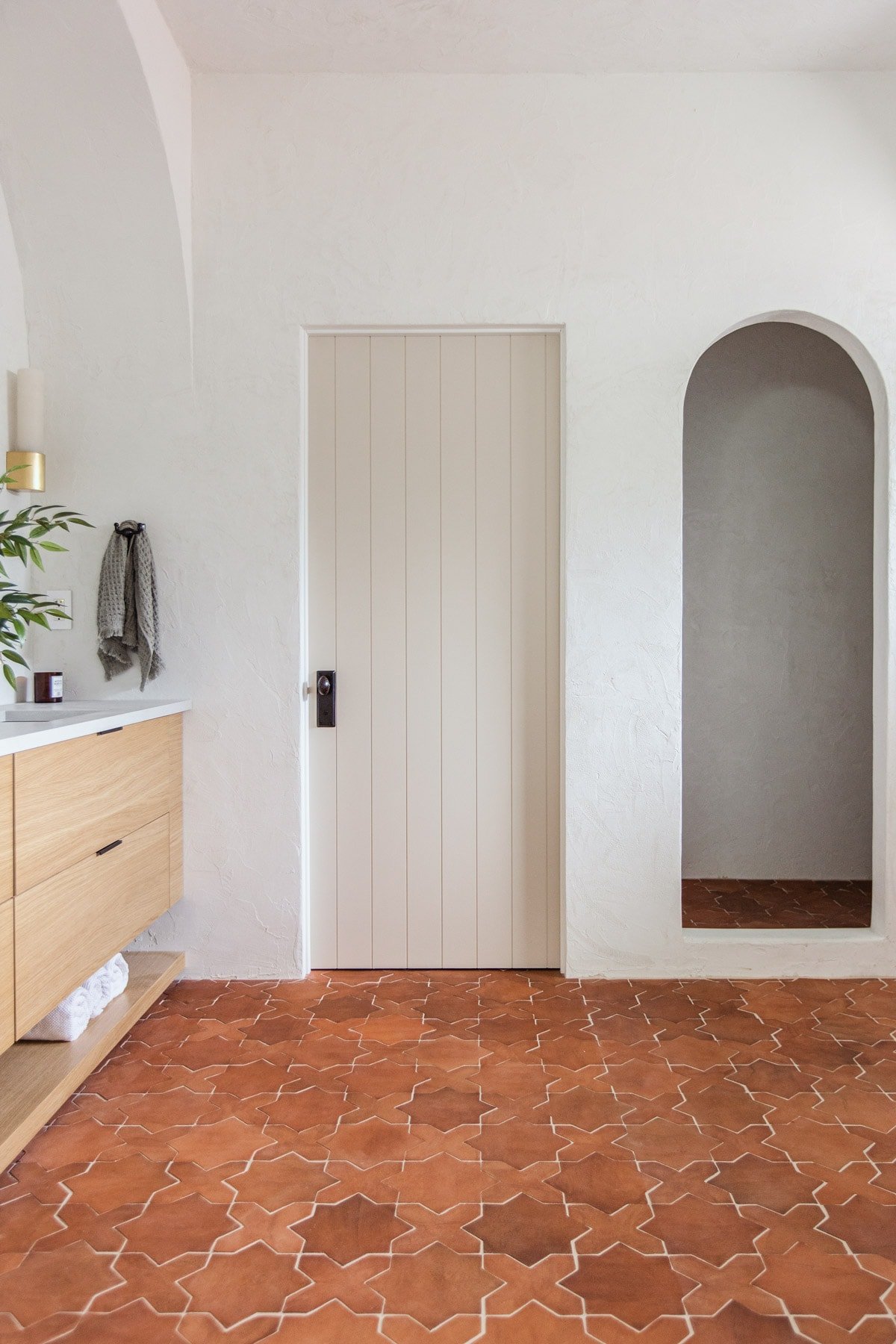 rustic mediterranean bathroom with clay tile and plank door
