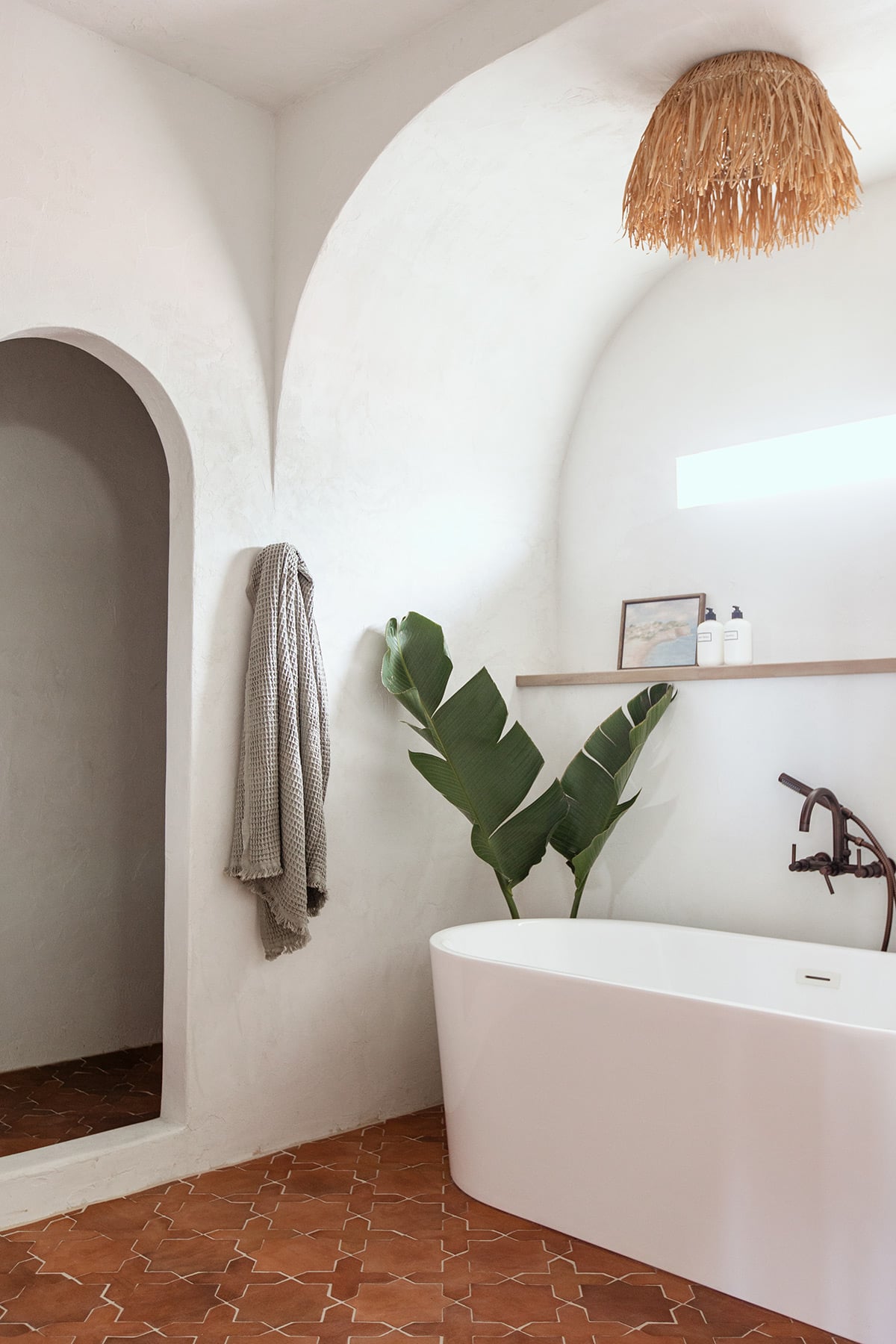 modern mediterranean bathroom with microcement walls and a tub alcove