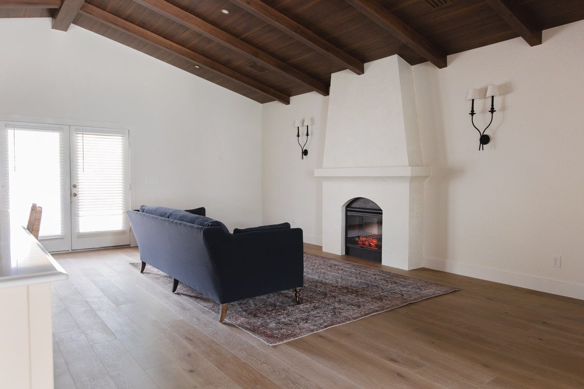 spanish style living room with wood beam ceilings and fireplace