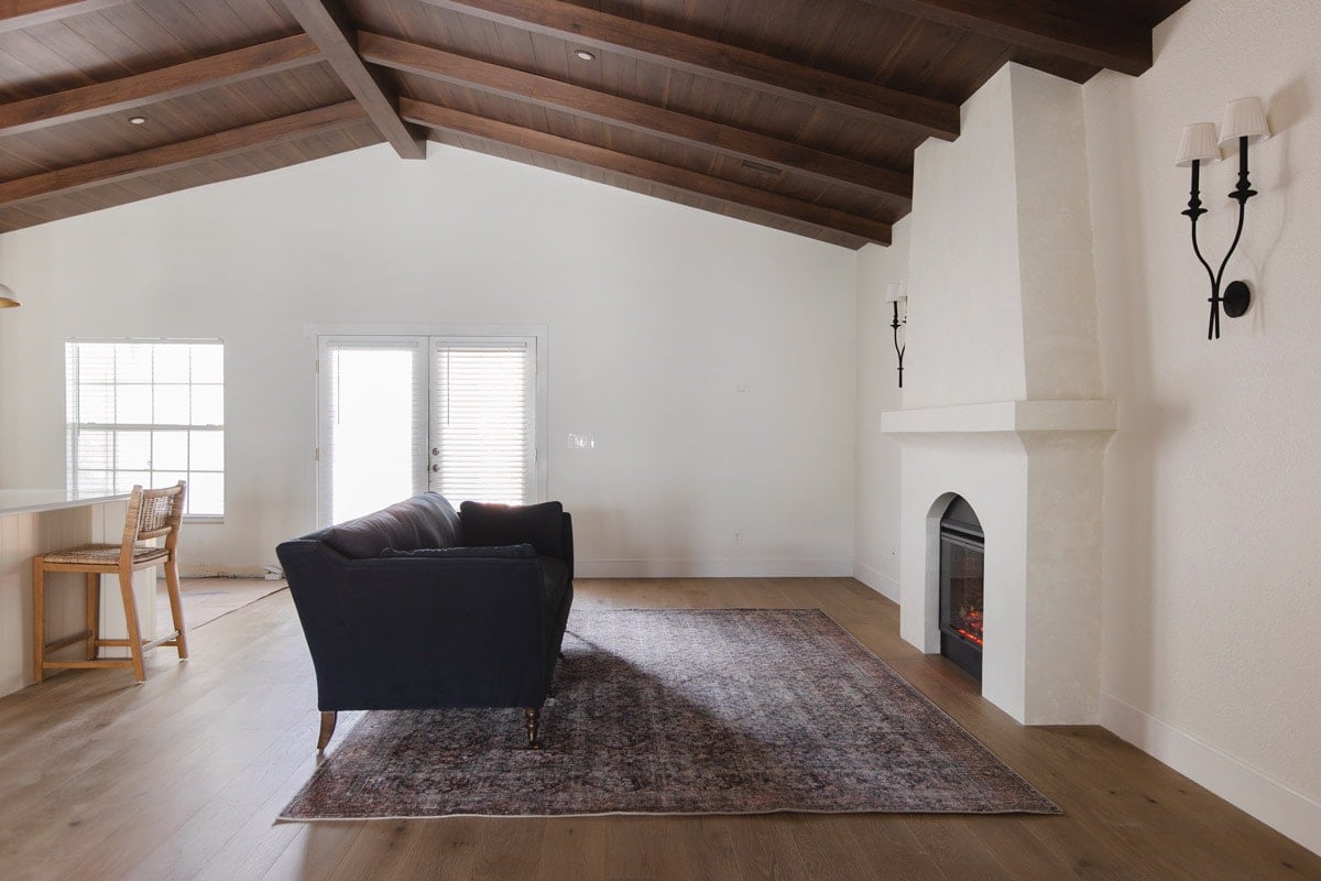 spanish style living room with wood beam ceilings and fireplace