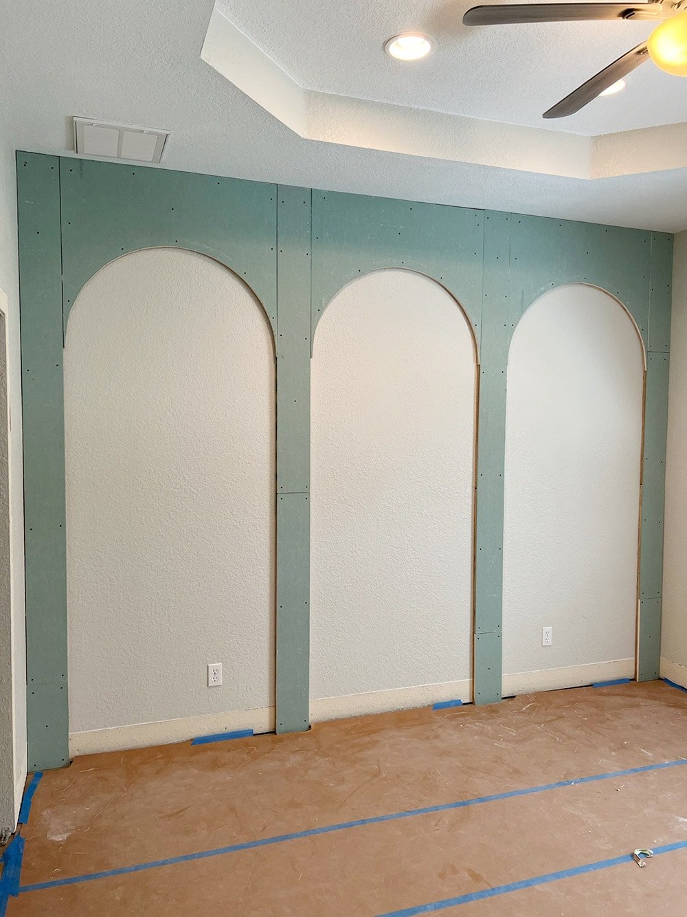 process shot of installling drywall arches on bedroom wall