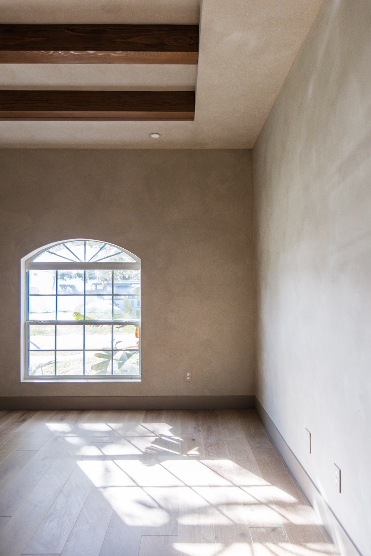 bedroom with lime wash and dark wood beams