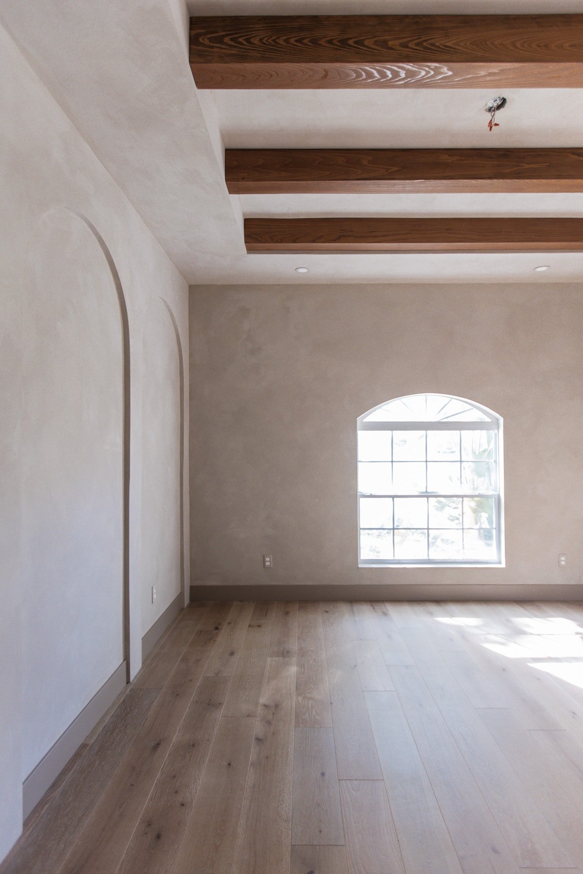 bedroom with lime wash and dark wood beams